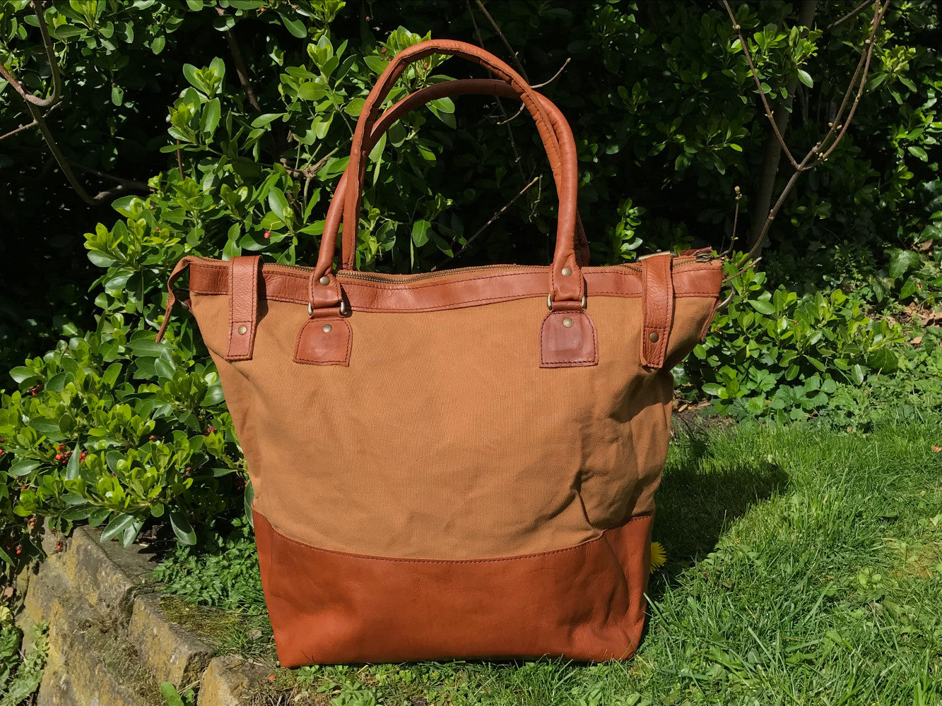 The Bingham.  A classic zipped tote bag by Burghley Bags.  Handmade from eco-friendly vegetable tanned leather and strong cotton canvas, with a leather shoulder strap.  Shown in classic tan.