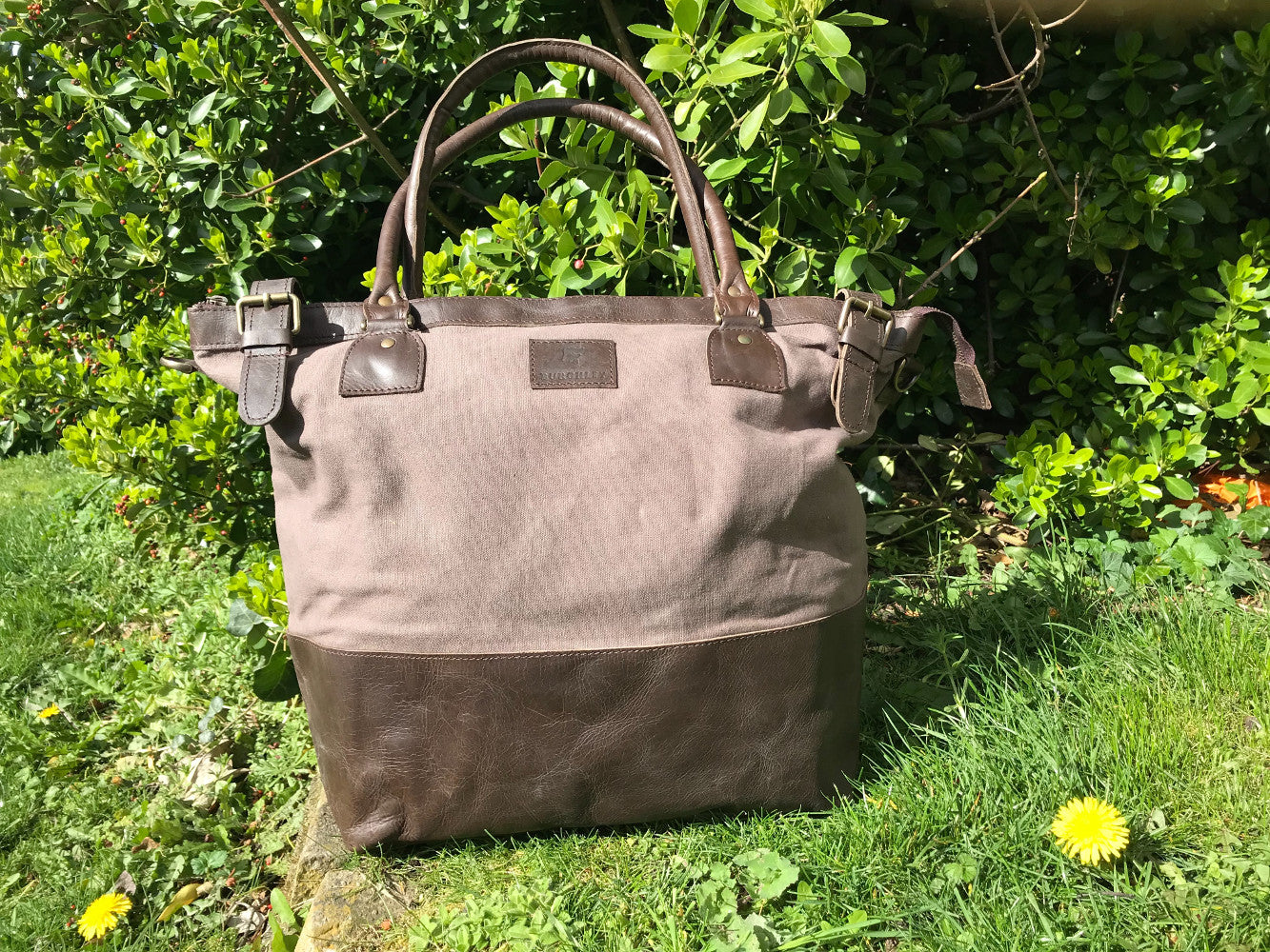 The Bingham.  A classic zipped tote bag by Burghley Bags.  Handmade from eco-friendly vegetable tanned leather and strong cotton canvas, with a leather shoulder strap.  Shown in soft grey.