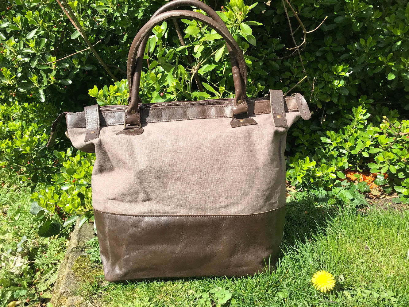 The Bingham.  A classic zipped tote bag by Burghley Bags.  Handmade from eco-friendly vegetable tanned leather and strong cotton canvas, with a leather shoulder strap.  Shown in soft grey.
