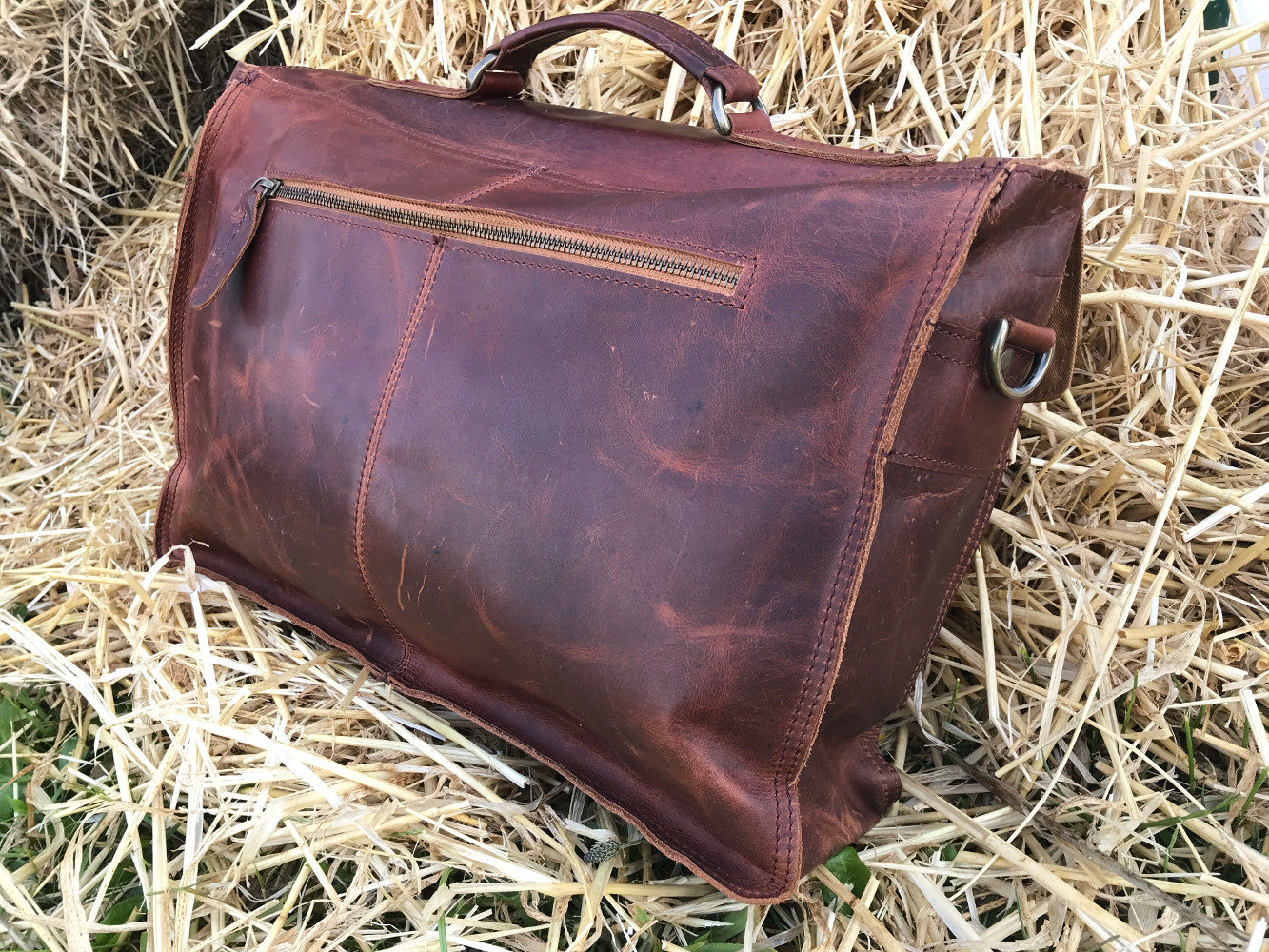 The Dorrington Briefcase. A classic 30's styled leather briefcase by Burghley Bags. A handmade leather vintage work bag, with enough space for 15" laptops. Comes with an adjustable and detachable shoulder strap. Vintage brown back showing zip pocket.