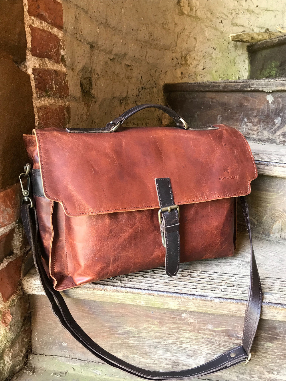 The Dorrington Briefcase. A classic 30's styled leather briefcase by Burghley Bags. A handmade leather vintage work bag, with enough space for 15" laptops. Comes with an adjustable and detachable shoulder strap. Shown in striking dual brown.
