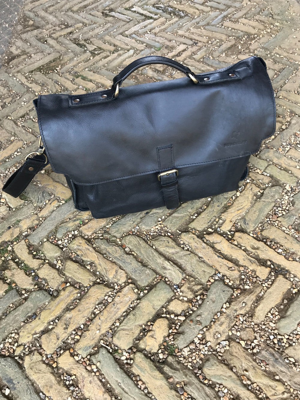 The Dorrington Briefcase. A classic 30's styled leather briefcase by Burghley Bags. A handmade leather vintage work bag, with enough space for 15" laptops. Comes with an adjustable and detachable shoulder strap. Shown in elegant black.