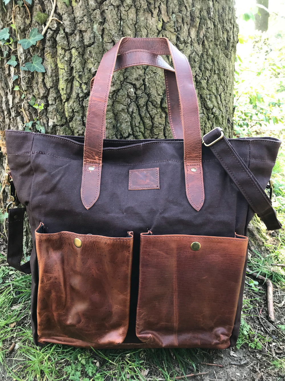 The Bingham.  A large zipped tote bag by Burghley Bags.  Handmade from eco-friendly vegetable tanned leather and strong cotton canvas, with a canvas shoulder strap. Shown in stylish maroon.